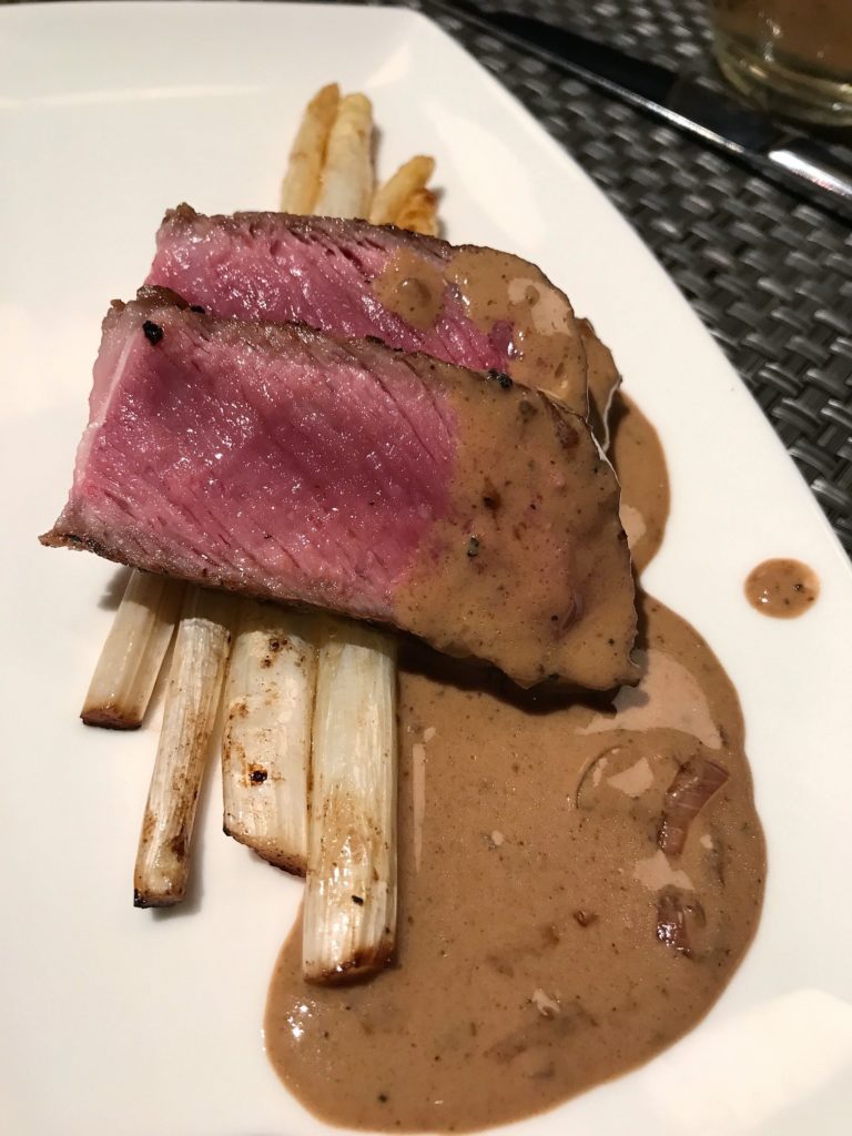 New York strip steak over white asparagus.